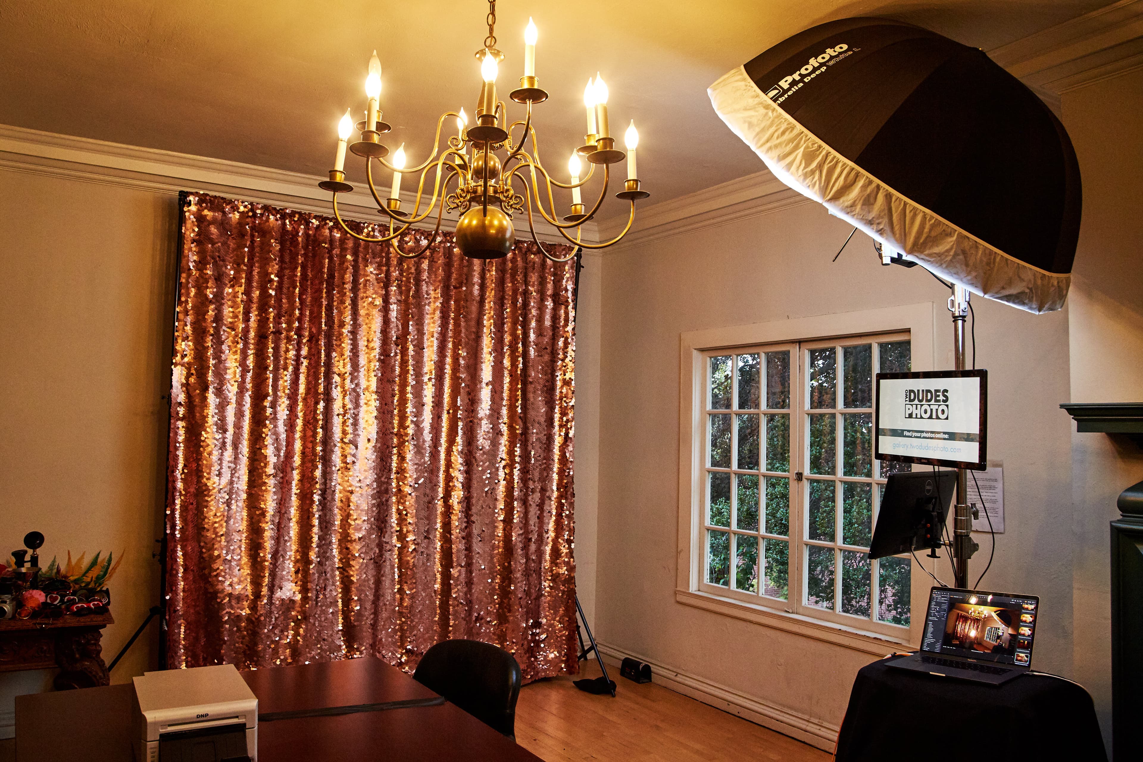 Our booth: a studio strobe in a big umbrella, a sequin backdrop, a photographer at the camera